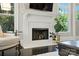 Close-up of a fireplace with white mantel, hearth, dark hardwood floors, and natural light from nearby windows at 21319 Baltic Dr, Cornelius, NC 28031