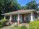 Charming brick home with a covered front porch, white columns, and lush landscaping at 226 S Morrow Ave, Albemarle, NC 28001