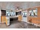 A kitchen with wood paneling, white cabinets, and a door to the exterior at 226 S Morrow Ave, Albemarle, NC 28001