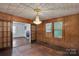Living room featuring wood paneling, hardwood floors, and a vintage chandelier at 226 S Morrow Ave, Albemarle, NC 28001