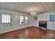 Vintage living room featuring hardwood floors, a brick fireplace, and a chandelier at 226 S Morrow Ave, Albemarle, NC 28001