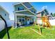 A spacious backyard featuring a covered patio, play set, and well-maintained lawn at 2526 Snow Creek Ne Rd, Hickory, NC 28601