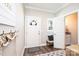 Bright entryway featuring a white front door, coat hooks, and an open view to the half-bath at 2526 Snow Creek Ne Rd, Hickory, NC 28601