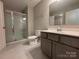 This bathroom features a glass enclosed shower, gray vanity, and neutral color palette at 284 Old Harbor Dr, Mount Gilead, NC 27306