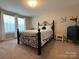 This cozy bedroom features a decorative wrought iron bed frame and soft natural light at 284 Old Harbor Dr, Mount Gilead, NC 27306