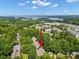 Aerial view of the property, set amongst lush trees in a residential neighborhood near a lake at 320 Magnolia St, Davidson, NC 28036