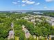 Panoramic aerial view of the neighborhood with lush trees and glimpse of a lake in the distance at 320 Magnolia St, Davidson, NC 28036