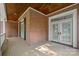 A private, covered porch featuring classic brickwork, perfect for enjoying the outdoors year-round with ceiling fans at 320 Magnolia St, Davidson, NC 28036