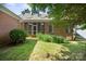 Home backyard showcasing a screened-in porch, brick exterior, manicured greenery, and natural light at 320 Magnolia St, Davidson, NC 28036