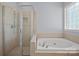 Bathroom featuring large walk-in shower and soaking tub with tile surround at 320 Magnolia St, Davidson, NC 28036