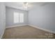 Bright bedroom featuring carpet, white shutters and trim, and a ceiling fan at 320 Magnolia St, Davidson, NC 28036