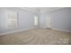 Bright bedroom featuring carpet, white shutters and trim, and a tray ceiling at 320 Magnolia St, Davidson, NC 28036