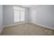 Bright bedroom featuring carpet, white shutters and trim, and a white door at 320 Magnolia St, Davidson, NC 28036