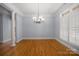 Bright and airy dining room with hardwood floors, decorative chandelier, and large windows with wooden shutters at 320 Magnolia St, Davidson, NC 28036