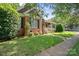 Brick home with shuttered windows, covered front porch, landscaped yard, and sidewalk access at 320 Magnolia St, Davidson, NC 28036
