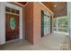 Close-up of a brick porch with a decorative wooden door and brick detail, offering curb appeal and character at 320 Magnolia St, Davidson, NC 28036
