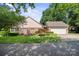 Charming brick home featuring a well-manicured front lawn, mature trees, and a spacious two-car garage at 320 Magnolia St, Davidson, NC 28036