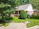 Traditional-style brick home with a welcoming front porch, lush lawn, and mature shade trees at 320 Magnolia St, Davidson, NC 28036