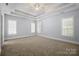 Main bedroom featuring tray ceilings, carpet flooring and plantation shutters at 320 Magnolia St, Davidson, NC 28036