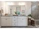 Beautiful bathroom featuring double sinks, white cabinetry, a walk-in shower with sleek tile design at 336 Secretariat Dr, Iron Station, NC 28080