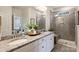 Elegant bathroom featuring double sinks, granite countertops, and a walk-in shower with sleek tile design at 336 Secretariat Dr, Iron Station, NC 28080