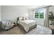 Bright bedroom features a comfortable bed, chair and large window offering natural light and outdoor views at 336 Secretariat Dr, Iron Station, NC 28080