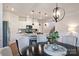 Dining room with a stylish chandelier overlooking a kitchen with stainless appliances and granite countertops at 336 Secretariat Dr, Iron Station, NC 28080