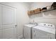 Functional laundry room with modern washer and dryer units, along with convenient shelving for storage solutions at 336 Secretariat Dr, Iron Station, NC 28080