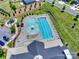 Aerial view of a community pool with a sundeck, swimming lanes, splash pad, playground, and parking at 336 Secretariat Dr, Iron Station, NC 28080