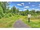 Entrance to nature walking trail, surrounded by lush greenery and a bright blue sky at 336 Secretariat Dr, Iron Station, NC 28080