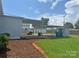 Exterior view of a backyard with a carport, grassy lawn, and mulch at 3412 1St Avenue Nw Cir, Hickory, NC 28601