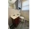 Compact bathroom featuring vinyl flooring, a single sink vanity, overhead storage, and a toilet at 3412 1St Avenue Nw Cir, Hickory, NC 28601