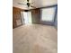 Spacious bedroom with wood paneling, plush carpeting, a ceiling fan, and natural light from the window at 3412 1St Avenue Nw Cir, Hickory, NC 28601