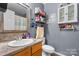 Bathroom featuring gray walls, floating shelves, vanity, a mirror and toilet at 431 Forest Dr, Maiden, NC 28650
