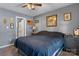 A bedroom with gray walls, dark furniture, and art on the walls. Door leading to bathroom at 431 Forest Dr, Maiden, NC 28650