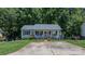 Cozy home featuring a welcoming front porch, American flag and lush green lawn at 431 Forest Dr, Maiden, NC 28650
