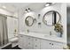 Modern bathroom with a double vanity, marble countertops, sleek white cabinets, and round wood-framed mirrors at 440 Bridlewood Dr, Gold Hill, NC 28071