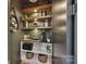 Walk-in pantry with open shelving, custom cabinets, microwave, and tile backsplash at 440 Bridlewood Dr, Gold Hill, NC 28071