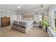 Spacious main bedroom featuring a tray ceiling, large bed, and natural light at 4408 Overbecks Ln, Waxhaw, NC 28173