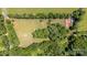Aerial view of expansive property featuring a house with red roof, surrounded by lush trees and open fields at 495 Brumley Rd, Mooresville, NC 28115