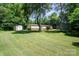 Large backyard with green grass, sheds, and a home with a cozy back porch at 495 Brumley Rd, Mooresville, NC 28115