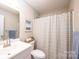 Bright bathroom featuring a vanity with sink, shower with blue patterned curtain, toilet, and minimalist decor at 50 Serenity Ln, Hickory, NC 28601