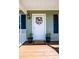 Inviting front door with a welcoming wreath, plants, and mat on a cozy, covered front porch at 50 Serenity Ln, Hickory, NC 28601