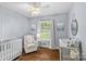 Adorable Bedroom with a crib, chair, decorative ceiling fan and a bright window with a view at 5501 Murrayhill Rd, Charlotte, NC 28210