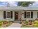Charming one-story home featuring a white brick exterior, black shutters, and landscaped garden at 5501 Murrayhill Rd, Charlotte, NC 28210