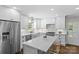 Gourmet kitchen featuring white cabinetry, quartz countertops, a stainless fridge, and an island with seating at 5501 Murrayhill Rd, Charlotte, NC 28210