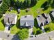 Aerial view of a home with a spacious backyard, mature trees, and a view of neighboring properties at 5822 Parkstone Dr, Matthews, NC 28104