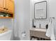 Updated bathroom with a granite countertop vanity, decorative mirror, and wooden medicine cabinet at 5822 Parkstone Dr, Matthews, NC 28104