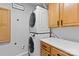 Efficient laundry room featuring stacked washer/dryer, ample oak cabinetry, and a clean, functional space at 5822 Parkstone Dr, Matthews, NC 28104