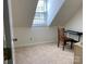 Well-lit attic bedroom featuring a skylight, chair, and keyboard at 6632 Summer Darby Ln, Charlotte, NC 28270